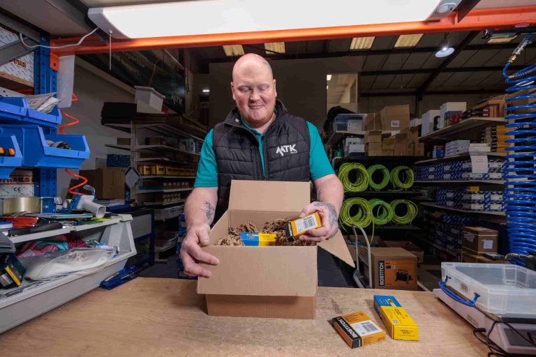 MTK warehouse manager Mark packs staples in eco friendly packaging at the bench