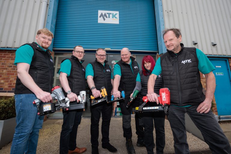 MTK Team all hold a tool outside the MTK Trade doors