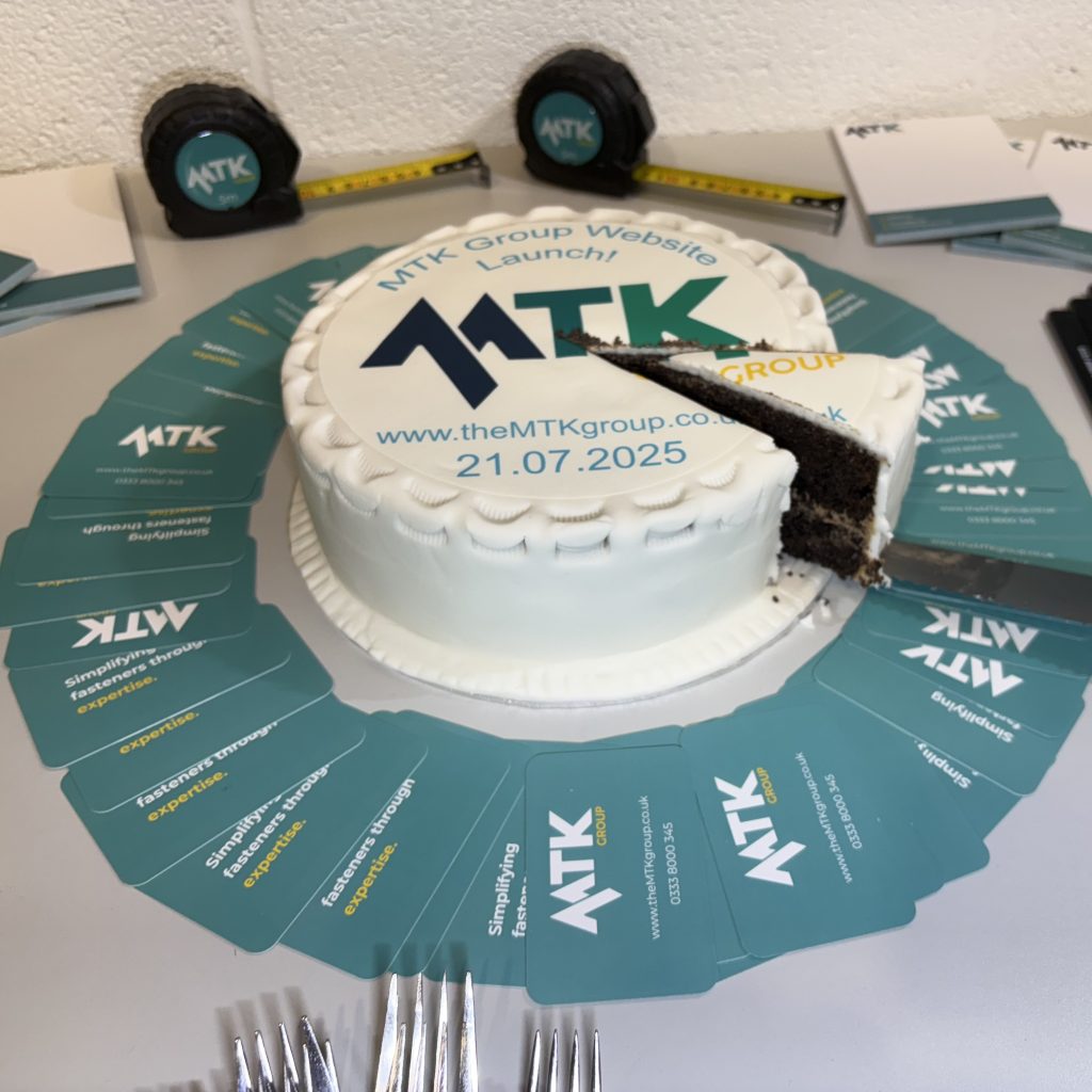 MTK New Website Celebration Branded Cake with a cut slice ready to be taken.